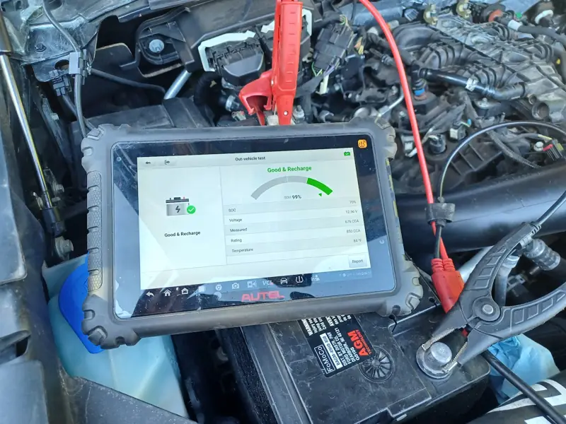 Autel diagnostic tablet clipped to a truck battery showing a good battery test result